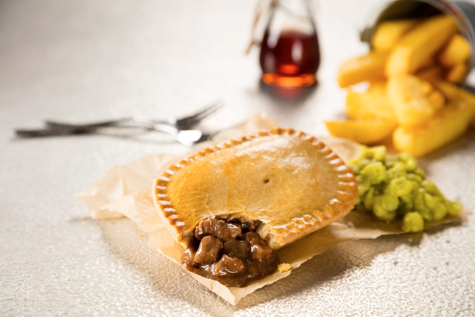 A Jasats pie served with chips and mushy peas